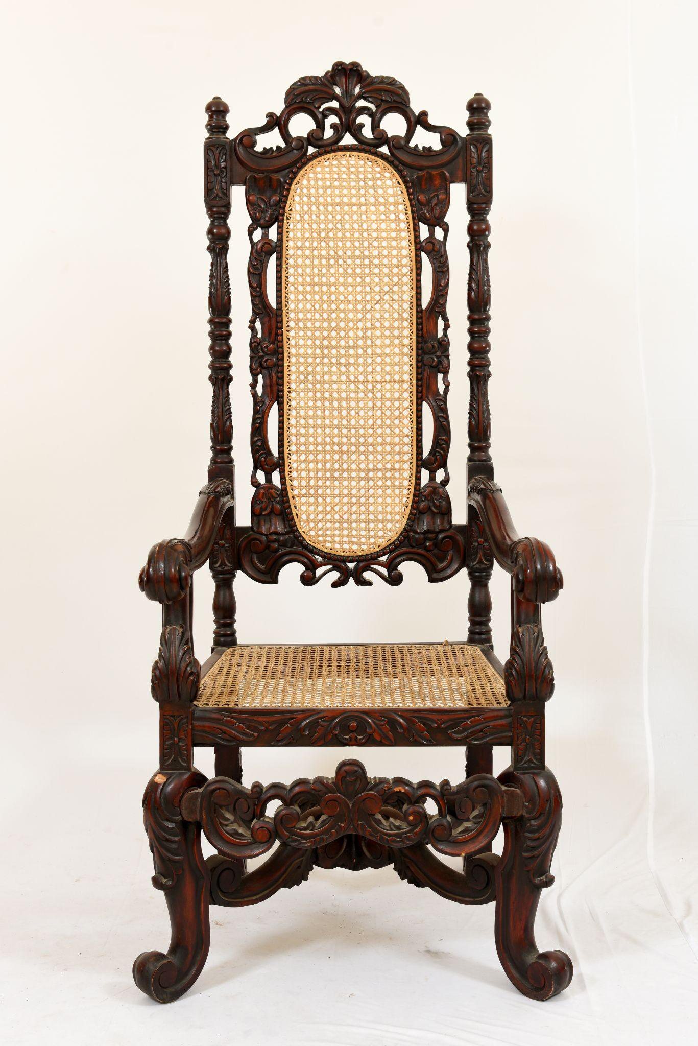 Antique ornate high-back throne chair with hand-carved detailing and woven cane